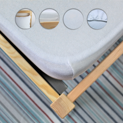 Colchão branco sobre estrutura de madeira clara com tapete riscado no chão