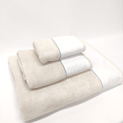 Conjunto de toalhas bege com bordas brancas e linha cinza empilhadas