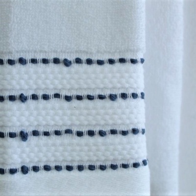 Toalha branca com linhas azul escuro texturizadas pendurada