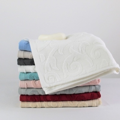 Toalhas de banho empilhadas com padrão floral em relevo, várias cores