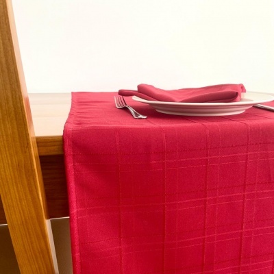 Mesa com toalha vermelha, pratos brancos e talheres