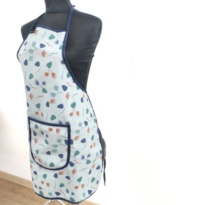 Avental branco com padrão de folhas coloridas e bolso frontal azul num manequim preto