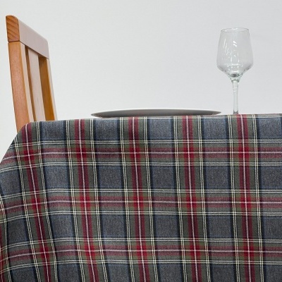 Toalha de mesa xadrez cinza, vermelho e branco com prato e copo sobre a mesa