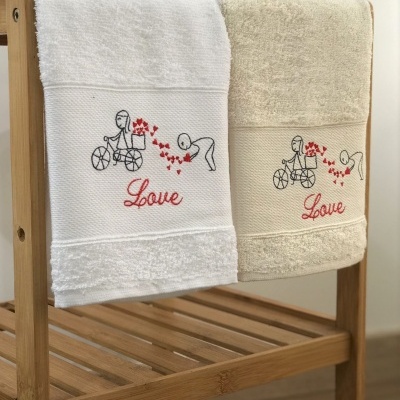 Duas toalhas bordadas penduradas num suporte de madeira