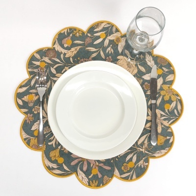 Pratos brancos sobre individual floral com talheres e copo