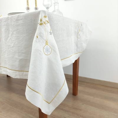 toalha de mesa branca com bordados dourados e decoração de Natal