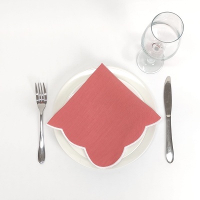 Mesa posta com prato branco, guardanapo vermelho, talheres em aço inox e copo de vidro