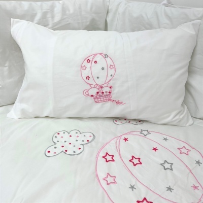 Almofada branca com bordado de balão de ar quente com ursos na cama com roupa de cama decorada
