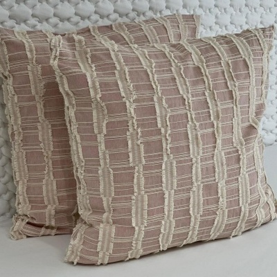 par de almofadas decorativas rosa e bege com padrão texturizado em superfície branca