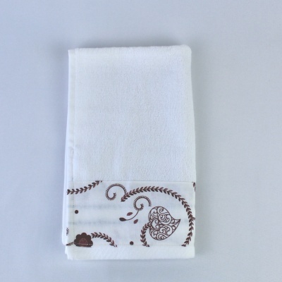 Toalha branca com bordado marrom em forma de coração e flores