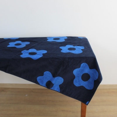 Manta azul escuro com flores azuis sobre mesa de madeira