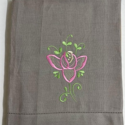 Toalha cinza com bordado de flor rosa e detalhes verdes