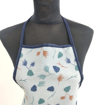 Avental com padrão de ramos e pinhas coloridas sobre fundo cinzento claro