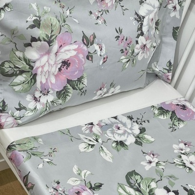 Conjunto de roupa de cama floral com fronhas e lençol em berço branco