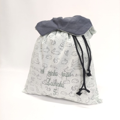 Saco de tecido branco com padrão de coelhos e cordão preto para fecho