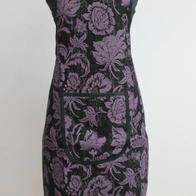 Avental preto com padrão floral roxo e bolso frontal