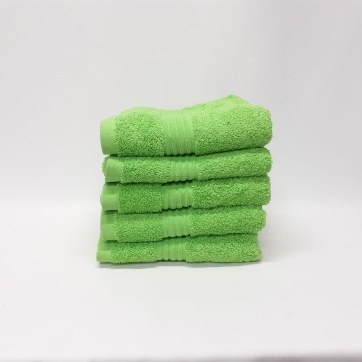 Toalhas de banho verdes empilhadas sobre fundo branco