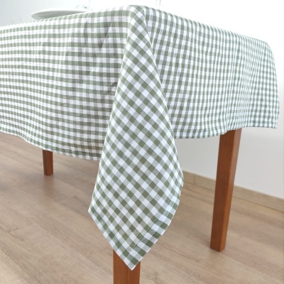 Toalha de mesa xadrez verde e branco sobre mesa de madeira