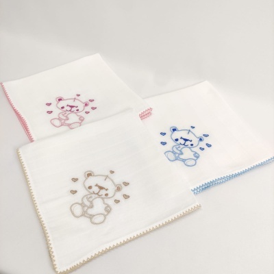 Três fraldas brancas com ursinhos bordados em rosa, azul e bege