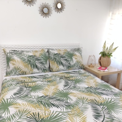 Conjunto de cama com padrão de folhas tropicais em tons verdes e amarelos