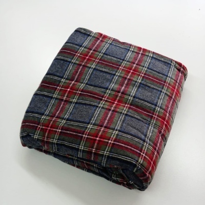 Cobertor xadrez dobrado em cores azul, vermelho, branco e verde