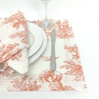 Guardanapo e toalhete de tecido branco com padrão terracota, prato branco, faca metálica e taça de vidro