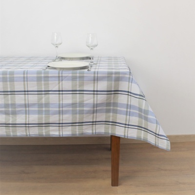 Toalha de mesa xadrez azul, cinza e branco sobre mesa de madeira com dois pratos e duas taças de vidro