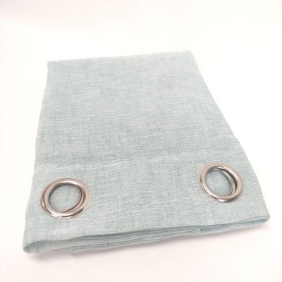 Cortina azul claro dobrada com ilhós metálicos prateados