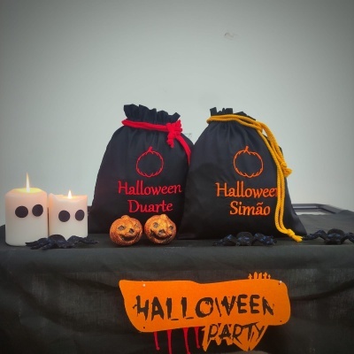 Sacos de tecido preto com nomes bordados e decoração de Halloween