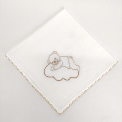 Toalha branca com bordado de urso a dormir numa nuvem e borda bege.