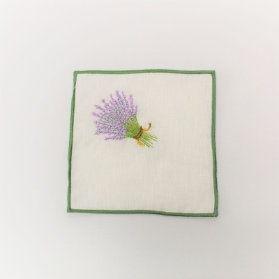 Guardanapo branco com borda verde e bordado de ramo de flores lilás ao centro