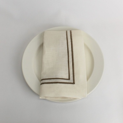 Guardanapo branco com linhas castanhas sobre prato branco