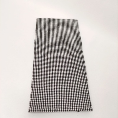 Pano preto e branco com padrão pied-de-poule sobre superfície branca