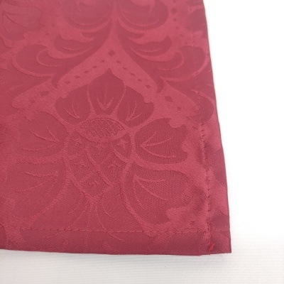 Pano vermelho com padrão floral em relevo e costura na borda