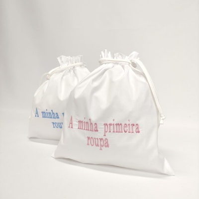 Duas bolsas de tecido branco com texto bordado colorido