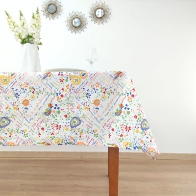 Toalha de mesa com padrão floral colorido sobre mesa de madeira clara