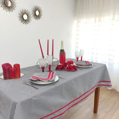 Mesa de jantar decorada com toalha xadrez e velas vermelhas