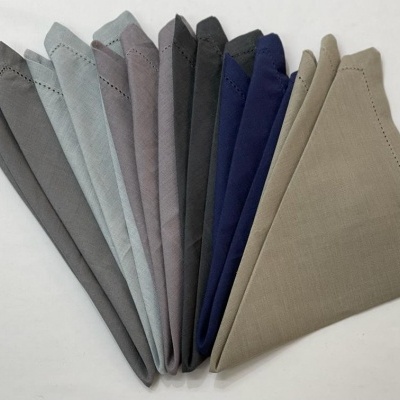 Lenços dobrados em várias cores sólidas dispostos em leque sobre fundo branco