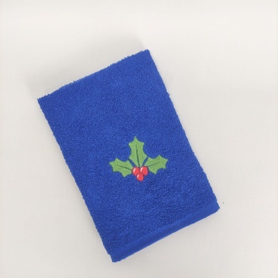 Toalha azul felpuda com bordado de folhas verdes e bagas vermelhas
