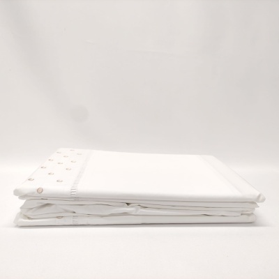 Conjunto de roupa de cama branco com botões redondos na dobra