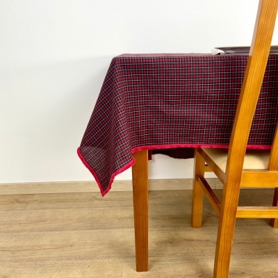 Toalha de mesa xadrez vermelha e preta sobre mesa de madeira clara