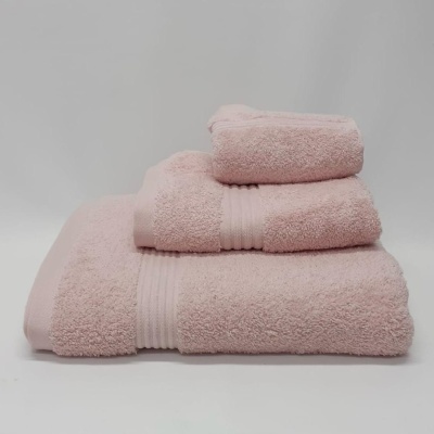 Conjunto de três toalhas cor-de-rosa claro empilhadas com textura felpuda e faixas horizontais.