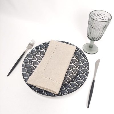 Conjunto de serviço de mesa com prato decorado, guardanapo, talheres e copo de vidro verde