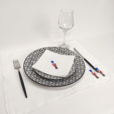 Conjunto de mesa com pratos, talheres, guardanapo bordado e copo de vidro