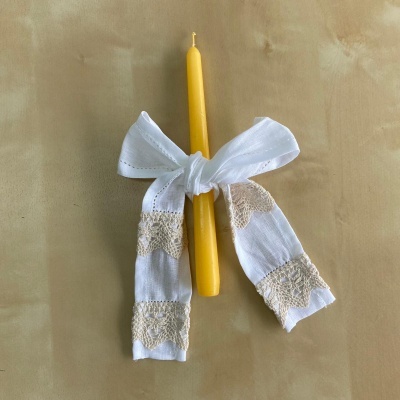 Vela amarela fina com laço branco de tecido com rendas