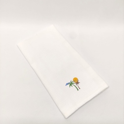 Toalha de cozinha branca com bordado colorido de planta, flor azul e sol amarelo