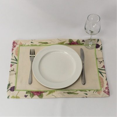 Conjunto de jantar com prato branco, talheres metálicos, copo de vidro e individual floral