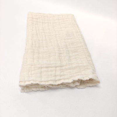 Toalha branca dobrada com textura de vincos sobre fundo branco