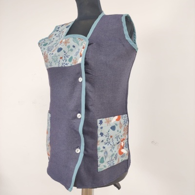 Colete cinza escuro com bolso e parte superior com padrão floral colorido em manequim preto