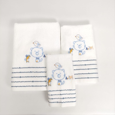 Três toalhas brancas bordadas com urso, passarinho e coelhinho, com riscas azuis.
